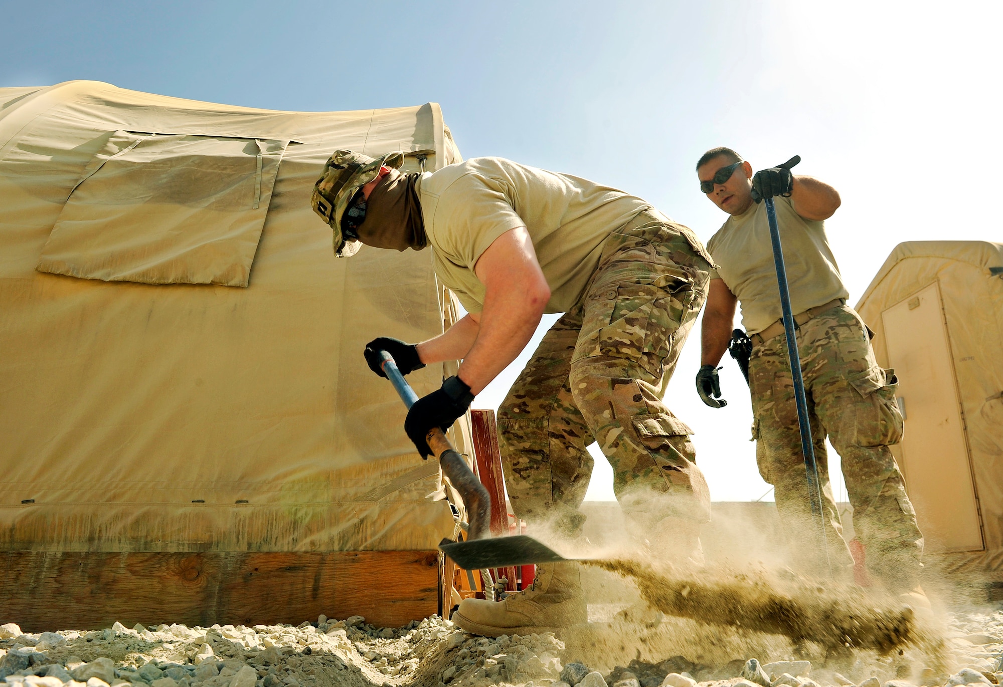 Capt. Wesley Parker, 455th Expeditionary Communications Squadron, operations flight commander, excavates trenches to hold conduit on Bagram Airfield, Afghanistan. The conduit will protect the fiber and copper cable running underground to the tents. He is deployed from Tinker Air Force Base, Okla., and is a native of Humble, Texas.