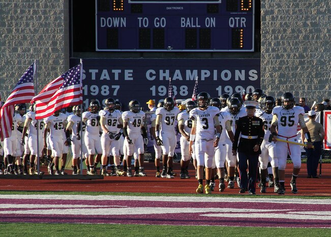 Sgt. Jose Gomez, recruiter, RS Indianapolis, leads the Warren Central varisty football team onto the Ben Davis football field to begin the Great American Rivalry Series game between Ben Davis and Warren Central Sep. 13.