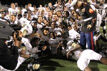 The varsity football players and Sgt. Jose Gomez, recruiter, RS Indianapolis pose for a photo with the Great American Rivalry Series Champions Trophy after defeating Ben Davis 24-7 Sep. 13.