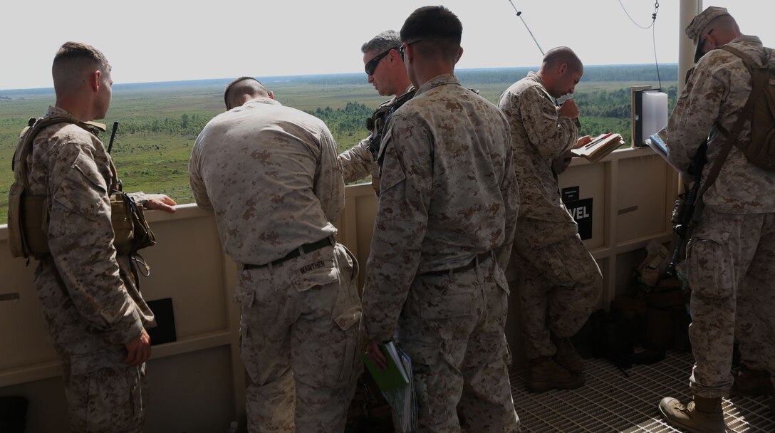 Marines from 2nd Air Naval Gunfire Liaison Company, II Marine Expeditionary Force, discuss the plan for the munitions drop while observing the target from an operations tower Sept. 11. The exercise is an annual training requirement that provides 2nd ANGLICO Joint Terminal Attack Controllers qualification to plan and request air support.