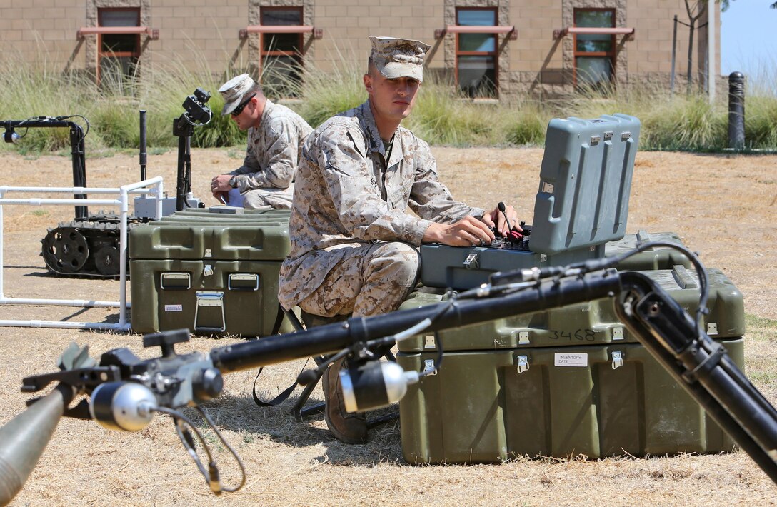 Sergeant James Smith, a combat engineer with Alpha Company, 7th Engineer Support Battalion, 1st Marine Logistics Group, operates a Foster-Miller TALON robot while it handles a dummy round aboard Camp Pendleton, Calif., Sept. 12, 2013. The robots are used for different tasks, such as identifying objects from far distances, placing charges to blow up improvised explosive devices in place, and handling smaller objects with precision. 
