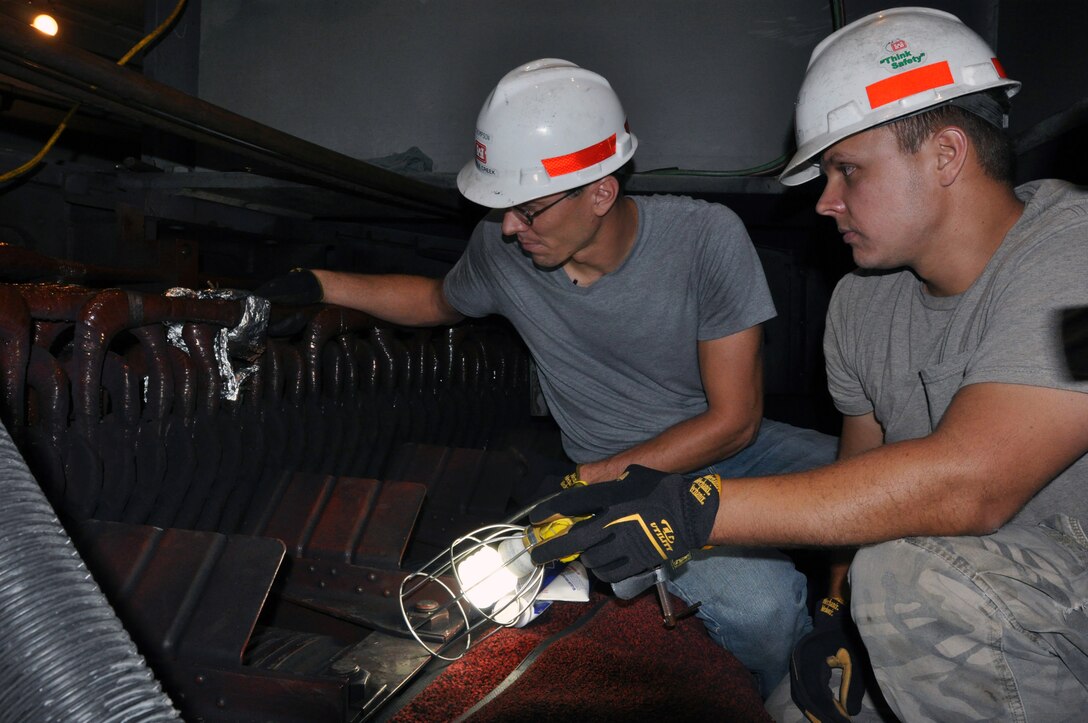 Brent Thompson, (left) and Jason Green, (right) both journeymen electricians at the Wolf Creek Power Plant make repairs to generator number three following an electrical ground fault shutdown of the generator. 