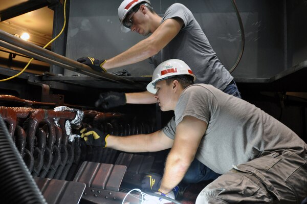 Brent Thompson, (left) and Jason Green, (right) both journeymen electricians at the Wolf Creek Power Plant make repairs to generator number three following an electrical ground fault shutdown of the generator. 