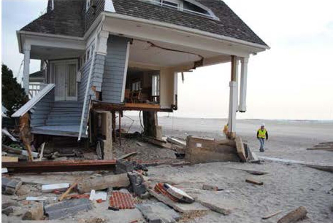 A U.S. Army Corps of Engineers New York Recovery Field Office debris engineer inspects a house devastated by Hurricane Sandy, in Queens, N.Y., Nov. 30, 2012.
