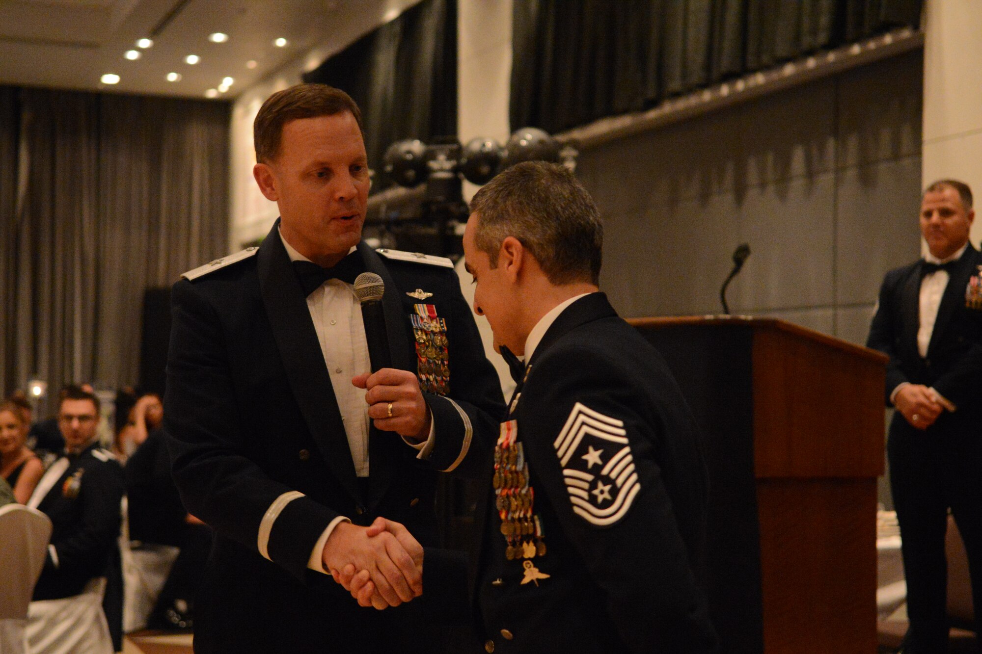 Brig. Gen. Steven Garland, 36th Wing commander, coins Chief Master Sgt. Ramon Colon-Lopez, 18th Wing command chief master sergeant, at the 66th Annual Air Force Ball Sept. 20, 2013, at Leo Palace in Yona, Guam. Colon-Lopez serves as the Kadena Air Base’s senior enlisted liaison between the 18th Wing and enlisted service members from five other Air Force major commands and joint partner units. (U.S. Air Force Photo by Airman 1st Class Emily A. Bradley/Released)