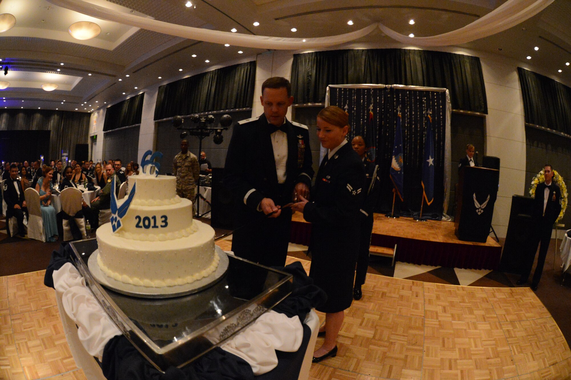 Brig. Gen.  Steven Garland, 36th Wing commander, and Airman 1st Class Miranda Woodruff, 734th Air Mobility Squadron passenger service agent, cut the Air Force birthday cake at the 66th Annual Air Force Ball Sept. 20, 2013, at Leo Palace in Yona, Guam. The cake is traditionally cut together by the Airman with the most time-in-service, and the Airman with the least time-in-service attending the event. (U.S. Air Force Photo by Airman 1st Class Emily A. Bradley/Released)