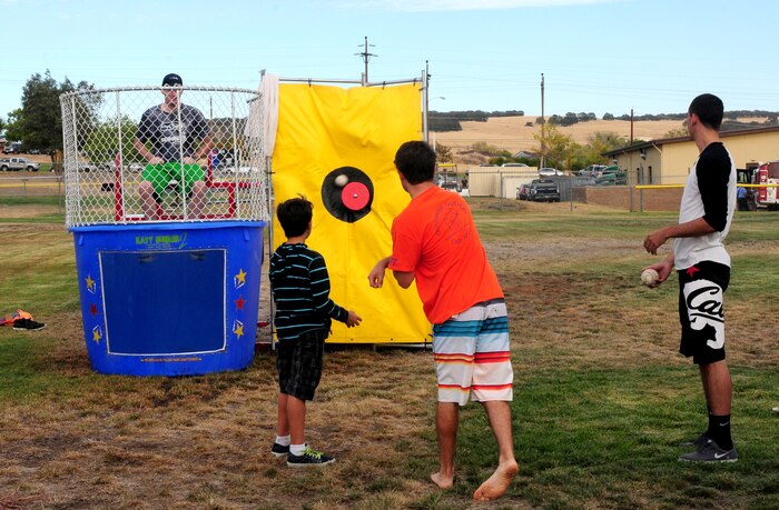 Beale youth use the dunk tank during Day for Kids outside the Youth Center on Beale Air Force Base, Calif., Sept. 20, 2013. The free event featured a BBQ, jump houses, rock wall and other activities for children. (U.S. Air Force photo by Senior Airman Allen Pollard/Released)