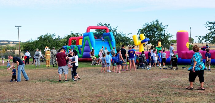 Team Beale partakes in outdoor festivities during Day for Kids at the Youth Center on Beale Air Force Base, Calif., Sept. 20, 2013. The free event featured a BBQ, jump houses, rock wall and other activities for children. (U.S. Air Force photo by Senior Airman Allen Pollard/Released)