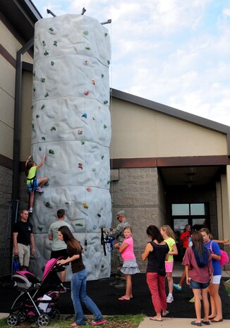 Beale youth climb a rock wall during Day for Kids outside the Youth Center on Beale Air Force Base, Calif., Sept. 20, 2013. The free event featured a BBQ, jump houses, rock wall and other activities for children.  (U.S. Air Force photo by Senior Airman Allen Pollard/Released)