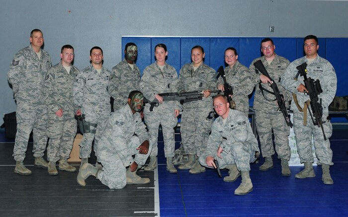 Members of the 9th Security Forces Squadron pose for a picture during the Jr. Personnel Deployment Function Line at the Youth Center on Beale Air Force Base, Calif., Sept. 20, 2013. This event was held to give military children the experience of what their parents go through during the pre-deployment process. (U.S. Air Force photo by Senior Airman Allen Pollard/Released)