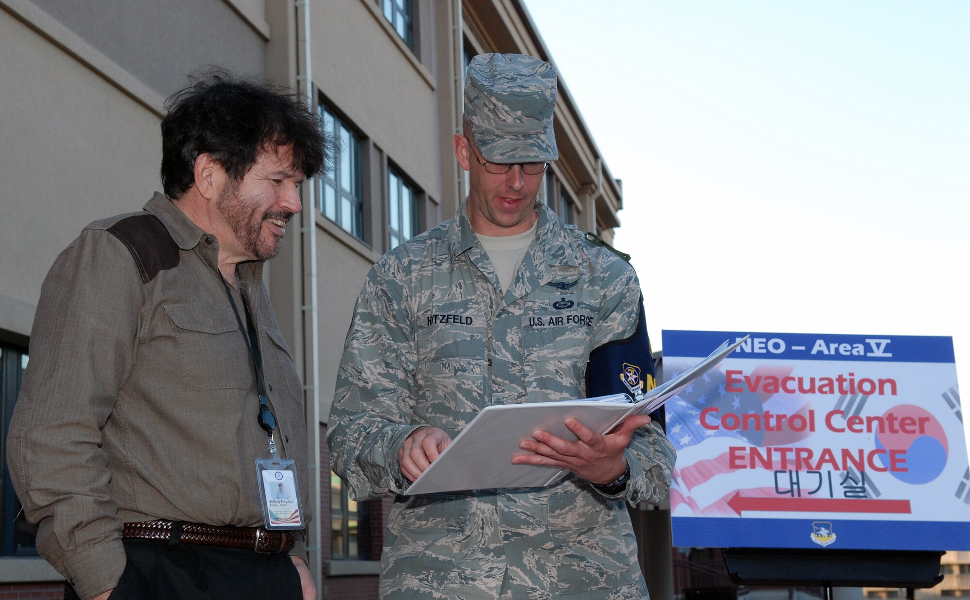 OSAN AIR BASE, Republic of Korea - NonCombat Evacuation Operations Marshaller Tech. Sgt. Robert Hotzfeld,Det. 2, 18th Intelligence Squadron, reviews a simulated evacuee's NEO folder at the Evacuation Control Center at Osan American High School during Exercise Courageous Channel on Osan Air Base, Republic of Korea, Sept. 25, 2013. Approximately 50 people processed through the NEO line Sept. 25 as a practice run for the larger lines expected when they open Sept. 27. Courageous Channel exercises the ability to move non-essential personnel out of danger zones on the Korean Peninsula in the event of hostilities or natural disasters. For more information about participating in Courageous Channel 2013, please call your NEO Warden or the Area V NEO Program Manager at 784-5440.  (U.S. Air Force photo by Tech. Sgt. Thomas J. Doscher)