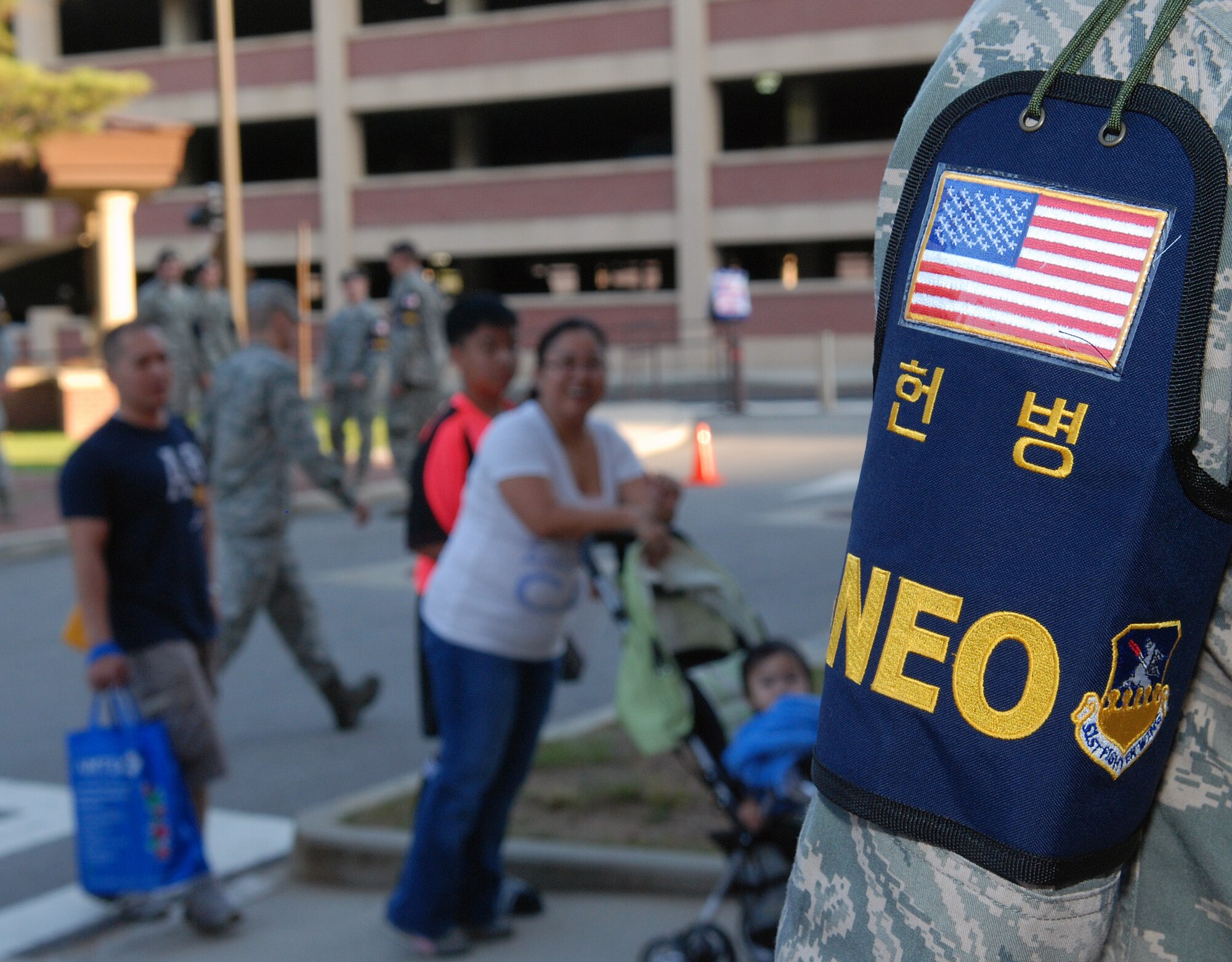 OSAN AIR BASE, Republic of Korea - NonCombat Evacuation Operations Marshaller Staff Sgt. Everett Cooper, 51st Force Support Squadron, directs simulated evacuees into the Evacuation Control Center at Osan American High School during Exercise Courageous Channel on Osan Air Base, Republic of Korea, Sept. 25, 2013. Approximately 50 people processed through the NEO line Sept. 25 as a practice run for the larger lines expected when they open Sept. 27. Courageous Channel exercises the ability to move non-essential personnel out of danger zones on the Korean Peninsula in the event of hostilities or natural disasters. For more information about participating in Courageous Channel 2013, please call your NEO Warden or the Area V NEO Program Manager at 784-5440.  (U.S. Air Force photo by Tech. Sgt. Thomas J. Doscher)