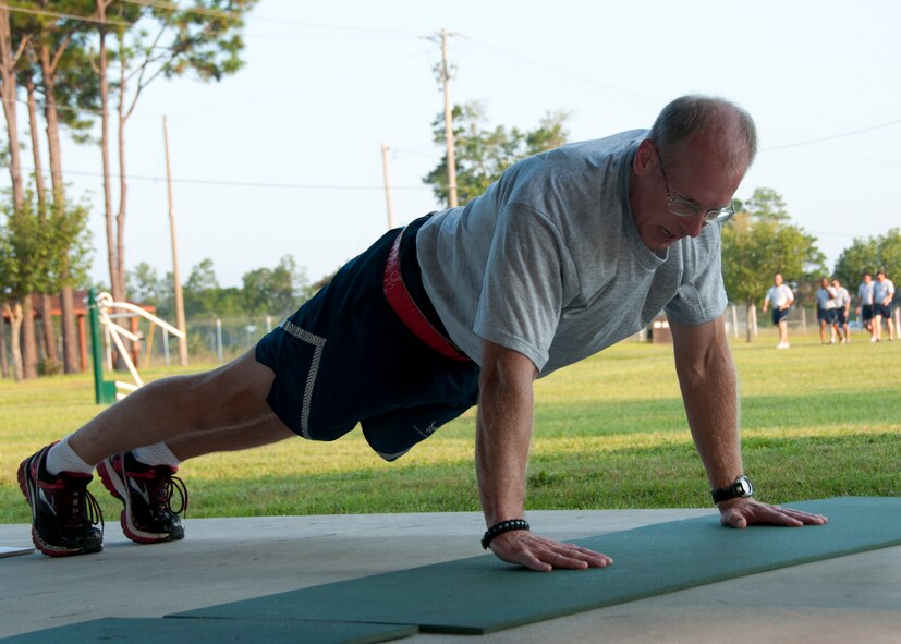 Air Force Reserve Senior Master Sgt. David Parcher, from the 919th Maintenance Squadron,  demonstrates proper push-up techniques during a unit physical training session at Duke Field, Fla., Sept. 7. The squadron begins each monthly unit training assembly with a mass stretching and calisthenics session before releasing members to finish individual workouts such as running, weight training, basketball, volleyball and more. (U.S. Air Force photo/Tech. Sgt. Jasmin Taylor) 