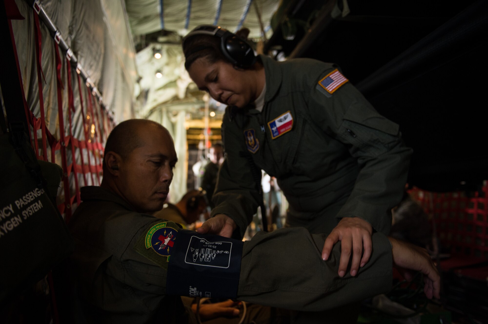 Air Force Reserve Master Sgt. Irene Alajmi, 433rd Aeromedical Evacuation Squadron emergency medical technician, checks a patient's vitals on a WC-130J from the 53rd Weather Squadron. during a aeromedical evacuation training mission at Joint Base San Antonio-Lackland, Texas, Sept. 19, 2013. The training allowed 433rd AES members to set up litter systems in conjunction with the aircraft's configuration, practice caring for patients in flight and simulate in-flight emergency procedures. The 53rd Weather Squadron, know as the Hurricane Hunters is based out of Keesler Air Force Base, Miss.  (U.S. Air Force photo/Staff Sgt. Jonathan Snyder)
