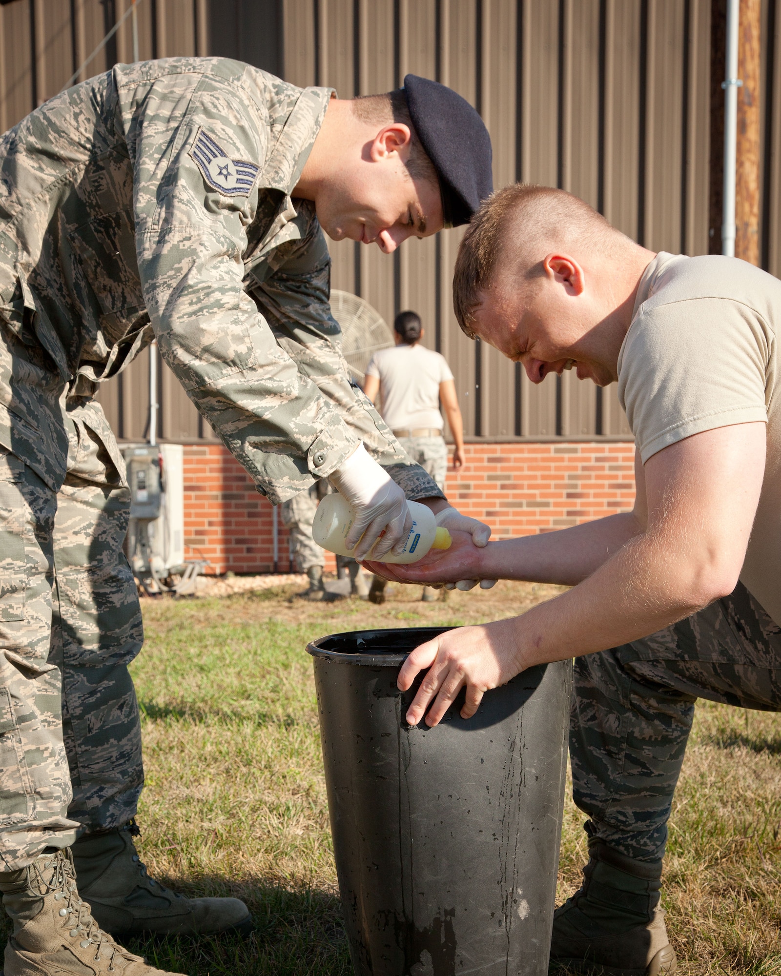 Staff Sgt. Michael Bringgold, 133rd Security Forces Squadron, assists Staff Sgt. Justin Schmitt, 133 SFS, wash the pepper spray off of his face after being exposed during a training exercise with the 934 SFS at the Minneapolis-St. Paul Air Reserve Station, Minn.  (U.S. Air Force photo/Shannon McKay)