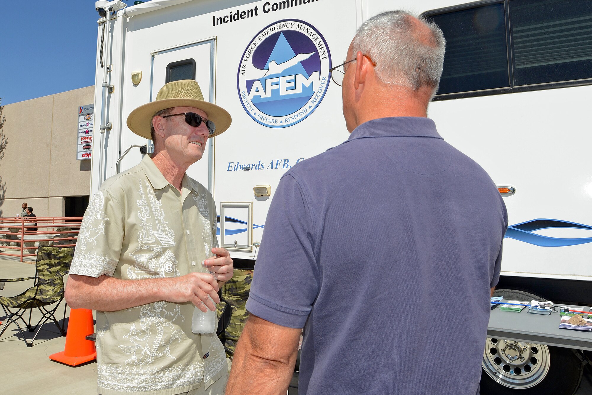Russell Warner, an Emergency Management specialist in the Plans and Programs section, speaks to a base employee during an EM demonstration in light of National Preparedness Month in front of the Base Exchange Sep. 18. The EM team had the Incident Command Post trailer on display for the base community to see and were handing out information pamphlets on how to prepare for natural or man-made disasters. (U.s. Air Force photo by Jet Fabara)