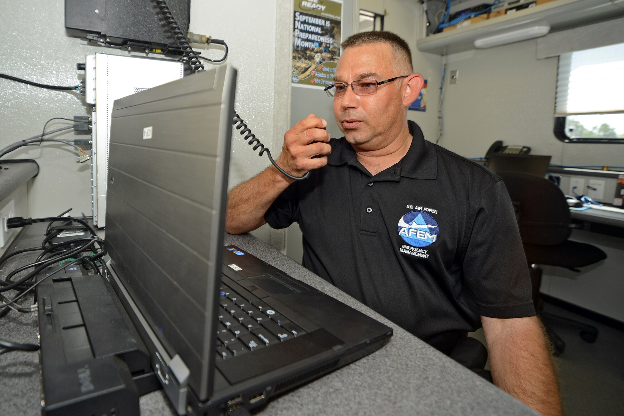 Phillip Langhus, a 412th Test Wing Emergency Management specialist in the Plans and Programs section, demonstrates one of the communication capabilities available to base personnel inside the Incident Command Post trailer Sep. 18., in front of the Base Exchange. The EM team is trained to ensure they provide the base and community with the best possible information in order for base personnel to be able to safely respond to and recover from small and large disasters. (U.S. Air Force photo by Jet Fabara)