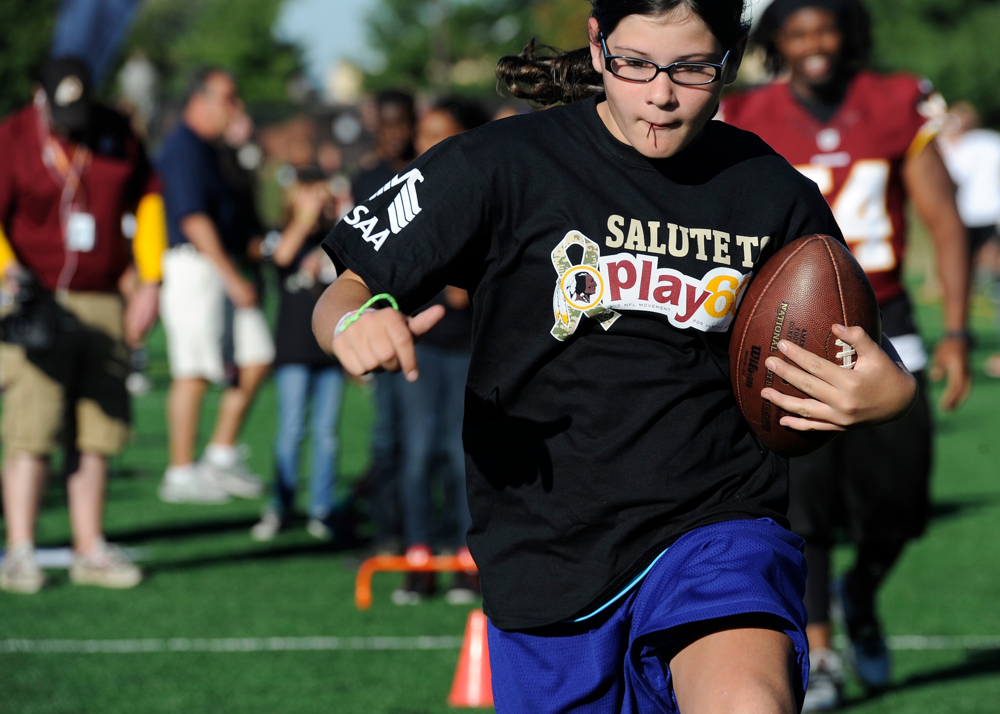 A military dependent runs a football drill during the Salute to Play 60 Military Challenge at Joint Base Andrews, Md., Sept. 24, 2013. Military families from the Army, Air Force, Navy and Marines participated in the event that kick-started a challenge encouraging families to track daily activity for four weeks. (U.S. Air Force photo/ Airman 1st Class Nesha Humes)

