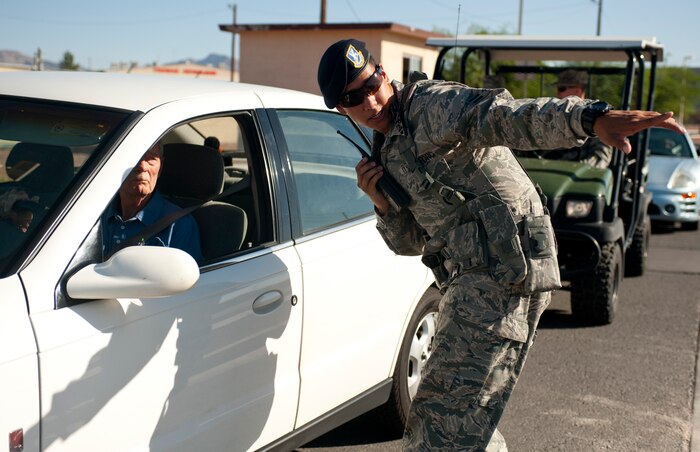 Airman 1st Class Kaikane Corpuz, 99th Security Forces Squadron entry point controller, diverts traffic away from a simulated aircraft crash area Sept. 19, 2013, near the Mike O’ Callaghan Federal Medical Center during a an aircraft crash response exercise at Nellis Air Force Base, Nev.  During the exercise, Airmen from the 99th SFS established a 1,000 foot cordon around the affected area and controlled who entered ad exited the scene. (U.S. Air Force photo by Staff Sgt. Michael Charles)