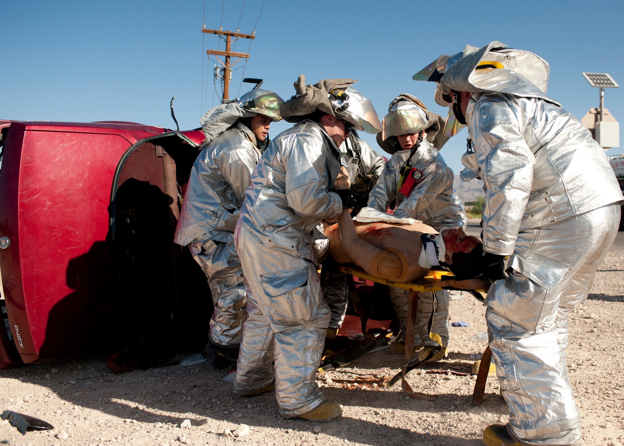 Airmen from the 99th Civil Engineer Squadron Fire Department extract a simulated victim from a vehicle Sept. 19, 2013, during an aircraft crash response exercise at Nellis Air Force Base, Nev.  Simulated victims were assessed for their medical condition on scene and transported to Mike O’ Callaghan Federal Medical Center for further treatment. (U.S. Air Force photo by Staff Sgt. Michael Charles)