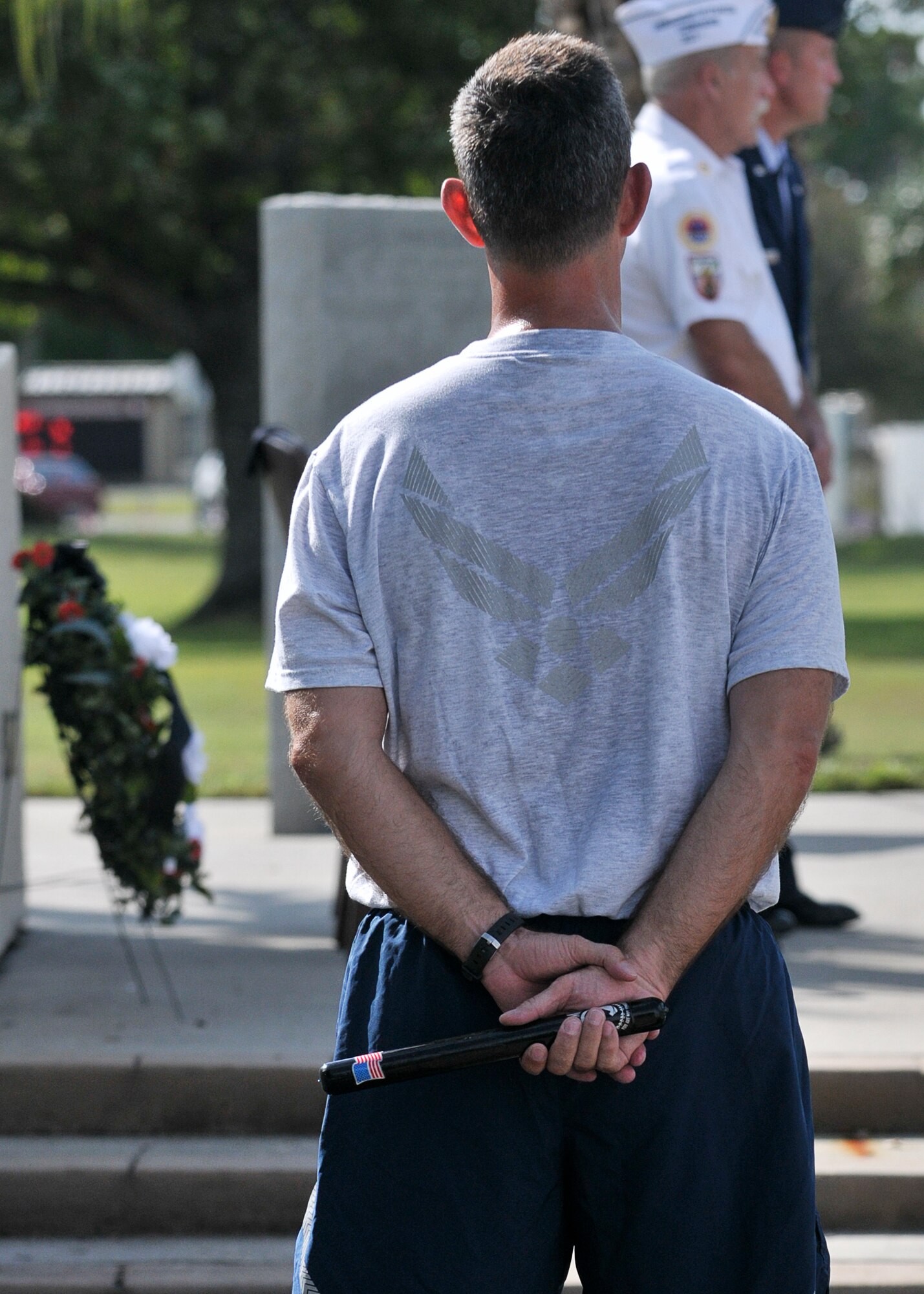 Lieutenant Colonel Bruce Bunce, 81st Range Control Squadron, Commander, waits to hand off the POW/ MIA baton that was carried by Airmen of Tyndall Air Force Base for 24-hours during the POW/MIA vigil run to Mr. Allen Bagett, AmVets Department of Florida, commander, at the closing ceremony  here Sept. 20. (U.S. Air Force Photo by Staff Sgt. Javier Cruz)