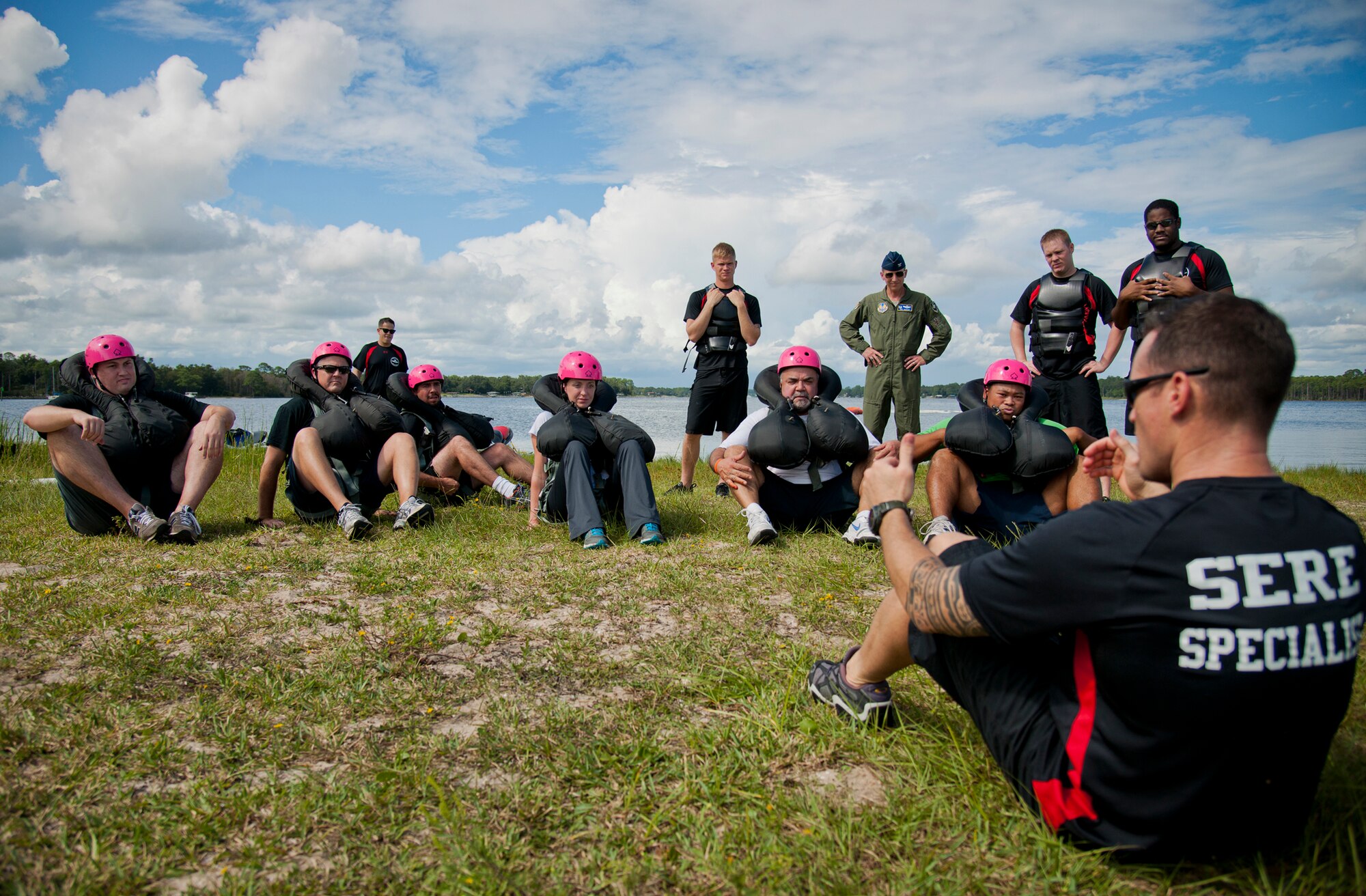 Staff Sgt. Joseph White, 96th Operations Support Squadron aircrew flight equipment, explains the proper position to be in during the towing exercise which simulates being drug by a parachute to the 96th Test Wing honorary commanders during their aircrew water survival orientation at Eglin Air Force Base, Fla., Sept. 23.  Designed for training pilots in the use of water survival equipment after an ejection over the sea or an emergency landing, the exercises provide an interactive environment for community members to work with Airmen. The honorary commander program pairs civic leaders and wing leadership together to exchange ideas and educate civilians about Air Force life. (U.S. Air Force photo/Samuel King Jr.)