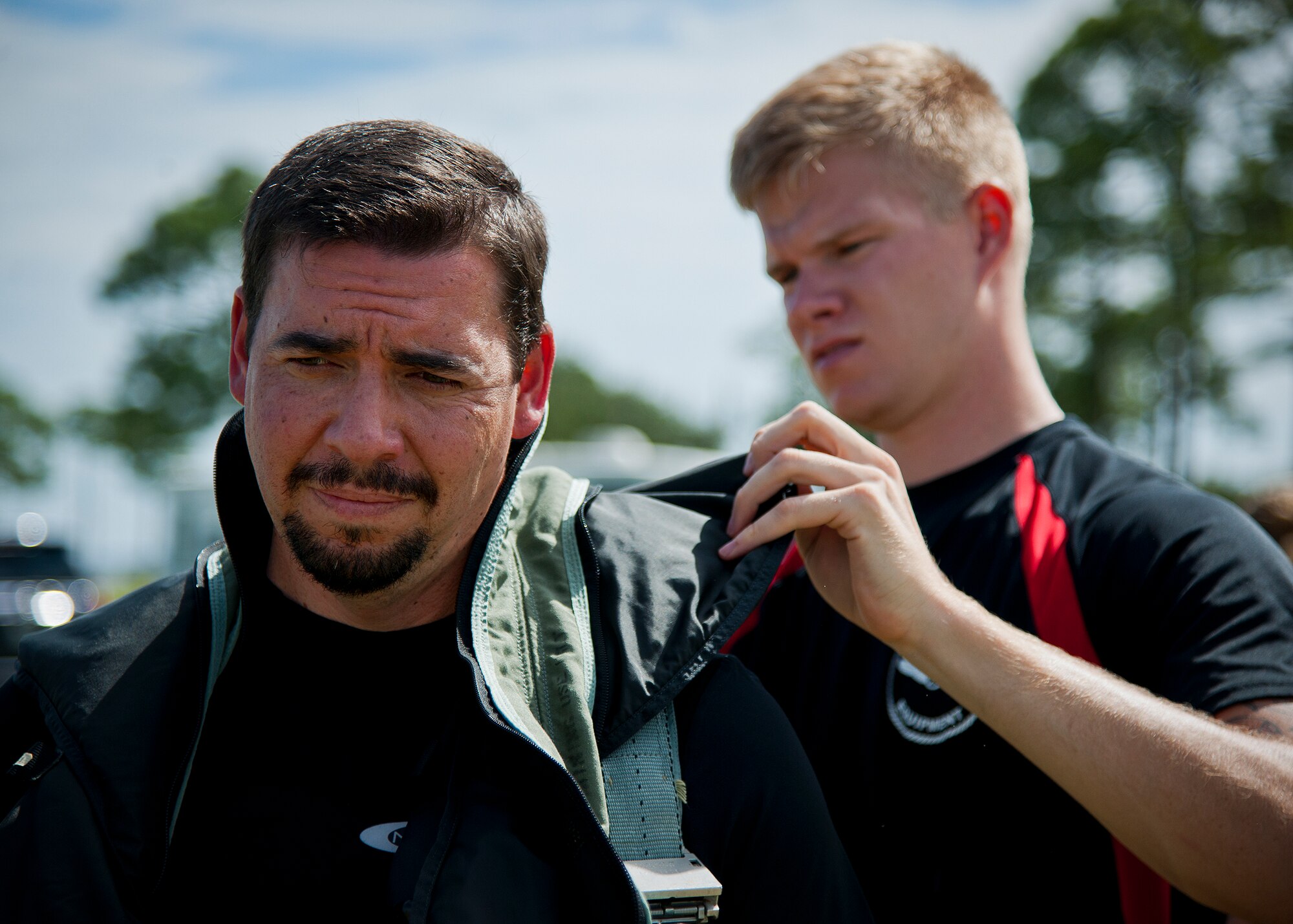 Michael Hamby, 96th Operations Group, gets help putting on his parachute harness from Staff Sgt. David Shirley, from the 96th Operations Support Squadron aircrew flight equipment, during the 96th Test Wing’s honorary commanders’ aircrew water survival orientation at Eglin Air Force Base, Fla., Sept. 23.  Designed for training pilots in the use of water survival equipment after an ejection over the sea or an emergency landing, the exercises provide an interactive environment for community members to work with Airmen. The honorary commander program pairs civic leaders and wing leadership together to exchange ideas and educate civilians about Air Force life. (U.S. Air Force photo/Samuel King Jr.)