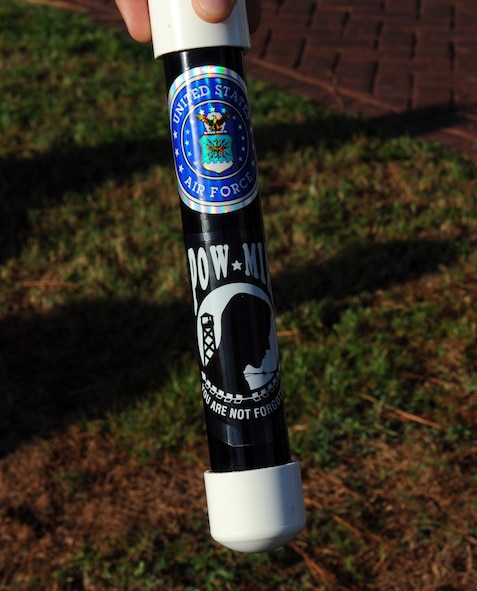 A Prisoner of War/Missing in Action baton is handed to a random Airman at the start of the three-mile commemorative run at the air park on Hurlburt Field, Fla., Sept. 20, 2013. The baton contains a list of POW/MIA names to be passed from Airman-to-Airman during the run until it made to the first place runner. (U.S. Air Force photo/Senior Airman Kentavist P. Brackin)