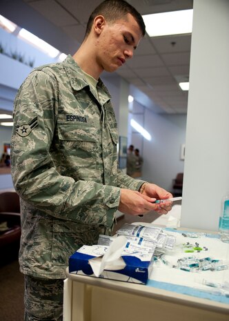 Airman 1st Class Andres Espinosa, 99th Medical Operations Squadron Family Health technician, prepares influenza vaccinations Sept. 23, 2013, in the lobby of Mike O’ Callaghan Federal Medical Center’s Immunization Clinic at Nellis Air Force Base, Nev. The Center for Disease Control traditionally characterizes flu season as starting in September and lasting until June the following year. (U.S. Air Force photo by Staff Sgt. Michael Charles)