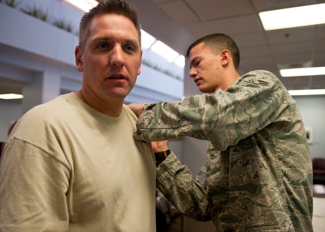 Airman 1st Class Andres Espinosa, 99th Medical Operations Squadron Family Health technician, gives an influenza shot to Master Sgt. Michael Thune, 99th Logistics Readiness Squadron F-16 Fighting Falcon aircraft parts store NCO in charge, Sept. 23, 2013, in the lobby of Mike O’ Callaghan Federal Medical Center’s Immunization Clinic at Nellis Air Force Base, Nev. The immunization clinic offers flu vaccinations to all military members, retirees and their families, Monday thru Friday from 7:30 a.m. to 4 p.m. (U.S. Air Force photo by Staff Sgt. Michael Charles)