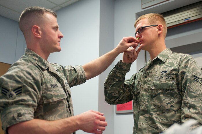 Senior Airman Frank Yuvan, 99th Medical Operation Squadron dermatology technician, gives Airman 1st Class Nicholas Lightcap, 823rd Maintenance Squadron crew chief, the influenza mist Sept. 23, 2013, in the lobby of Mike O’ Callaghan Federal Medical Center’s Immunization Clinic at Nellis Air Force Base, Nev. Family members as young as 6 months old are encouraged to get their influenza vaccinations early due to change in the weather. (U.S. Air Force photo by Staff Sgt. Michael Charles)