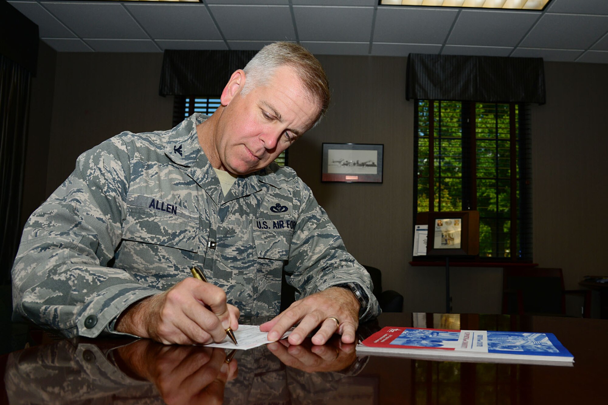 U.S. Air Force Col. John J. Allen Jr., 633rd Air Base Wing commander, fills out a donation card for the Combined Federal Campaign at Langley Air Force Base, Va., Sept. 23, 2013. The 2013 CFC will include a 5k run later this year, which will help in providing support for local, national and international charities. (U.S. Air Force photo by Staff Sgt. Ashley Hawkins/Released)