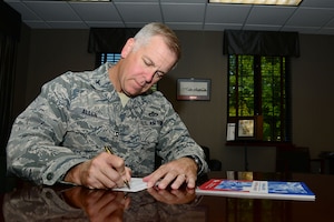 U.S. Air Force Col. John J. Allen Jr., 633rd Air Base Wing commander, fills out a donation card for the Combined Federal Campaign at Langley Air Force Base, Va., Sept. 23, 2013. The 2013 CFC will include a 5k run later this year, which will help in providing support for local, national and international charities. (U.S. Air Force photo by Staff Sgt. Ashley Hawkins/Released)