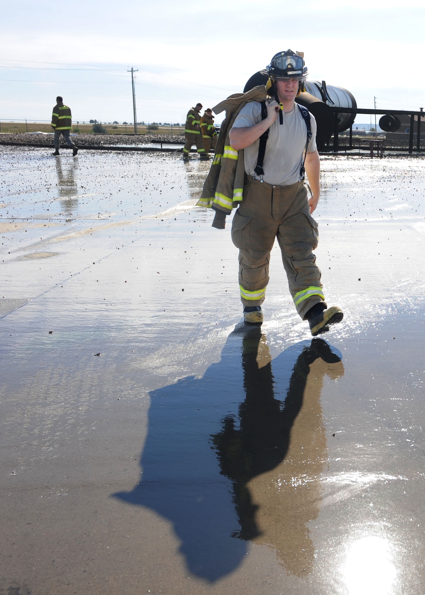 Senior Airman Clinton Gatewood, 28th Civil Engineer Squadron driver operator, walks back to a fire truck after participating in a pit burn training exercise at Ellsworth Air Force Base, S.D., Sept. 18, 2013. Fire pit training is conducted each quarter, ensuring all Airmen are proficient in performing their duties year-round. (U.S. Air Force photo by Airman 1st Class Rebecca Imwalle / Released)