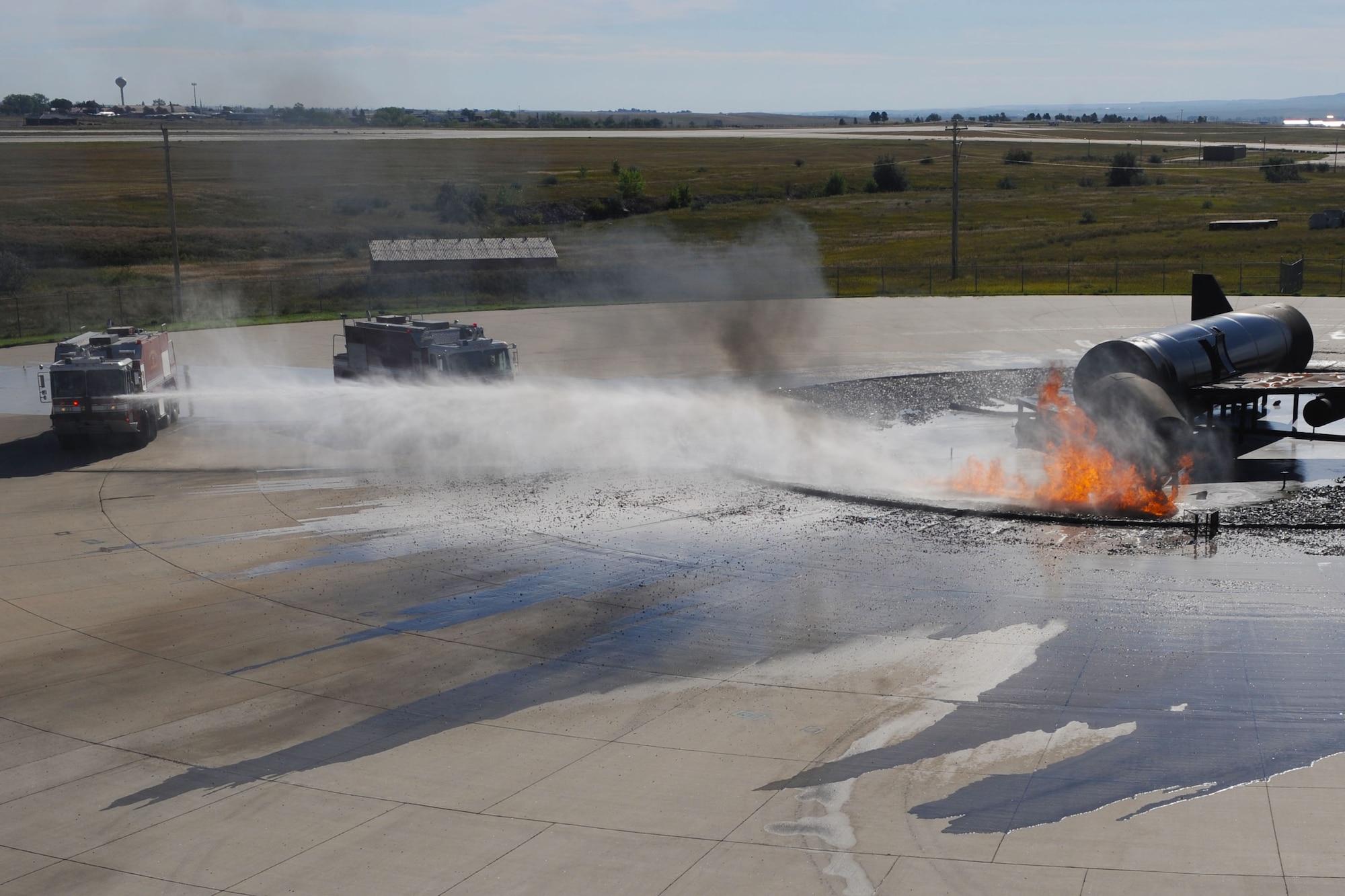 Aircraft rescue firefighting vehicles extinguish a simulated aircraft fire during a pit burn training exercise at Ellsworth Air Force Base, S.D., Sept. 18, 2013. ARF vehicles can hold up to3,300 gallons of water and the torrets are capable of releasing 250 gallons a minute. (U.S. Air Force photo by Airman 1st Class Rebecca Imwalle / Released)