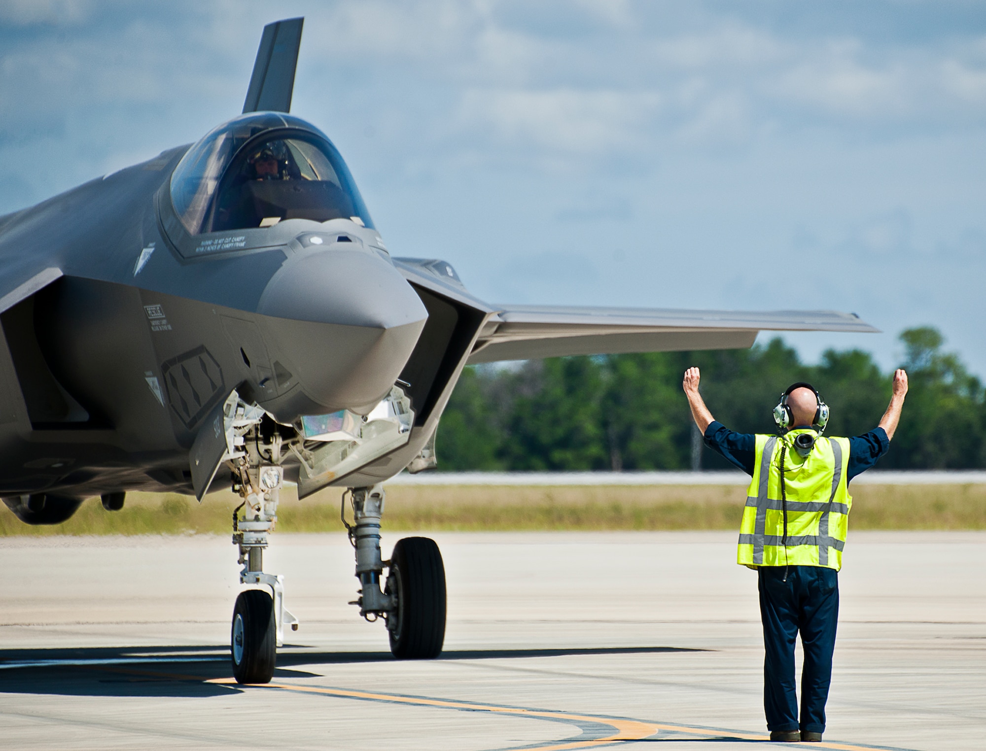 A maintainer from the 33rd Aircraft Maintenance Squadron, prepares to marhall an F-35A Lightning II after a hot pit session on the 33rd Fighter Wing flightline at Eglin Air Force Base, Fla.  Airmen, Marines and Sailors are refueling their F-35 variants for multiple sorties via 96th Test Wing fuel trucks while construction is completed on the 33rd’s hot pit area.  (U.S. Air Force photo/Samuel King Jr.)