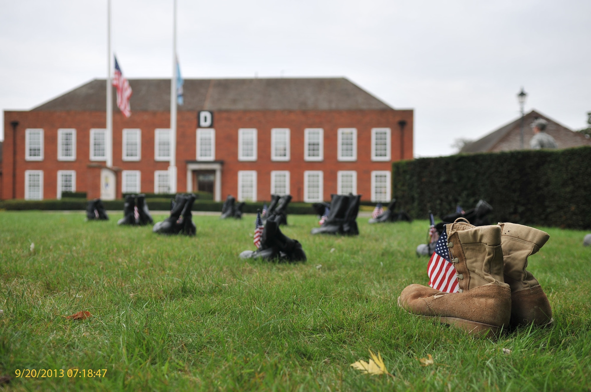 Combat boots lie on the grass in front of the 100th Air Refueling Wing headquarters building Sept. 20, 2013, on RAF Mildenhall, England. The boots were displayed as part of a 24-hour vigil held in honor of those POW/MIA. The vigil ended with a retreat ceremony in remembrance of those honored. (U.S. Air Force photo by Airman 1st Class Kyla Gifford/Released)