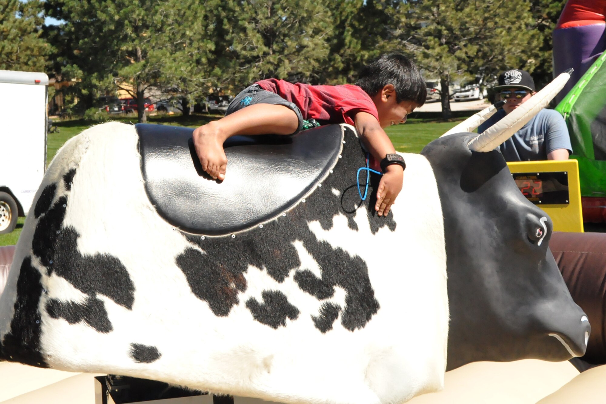 PETERSON AIR FORCE BASE, Colo. - Zamahry Strickland, 4, holds on while riding a mechanical bull during the Worldwide Day of Play at Patriot Park Sept. 21. Zamahry attended the event with his parents, Staff Sgt. Luis Strickland, 21st Civil Engineer Squadron and Cassandra Strickland. The mechanical bull was just one of the many activities there for kids. (U.S. Air Force photo/Tech. Sgt. Jared Marquis)