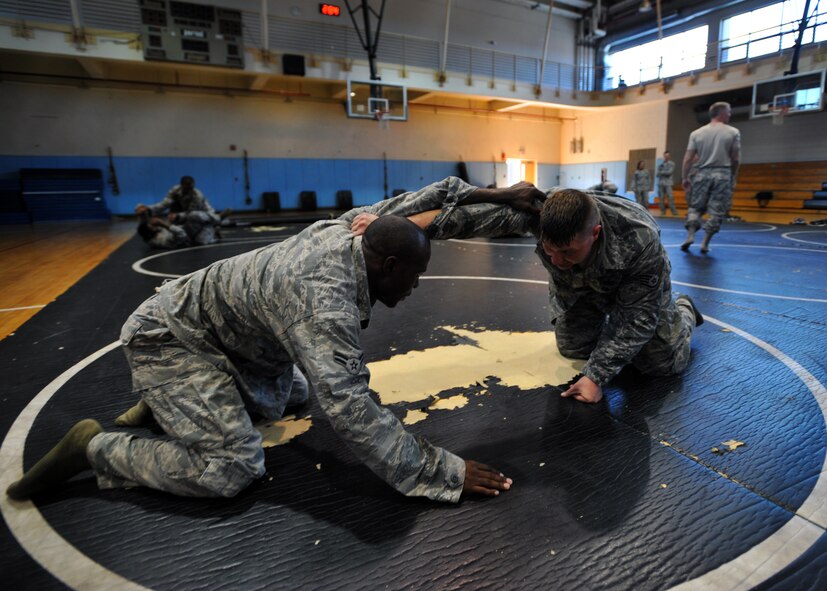 Airman 1st Class Kadeem Blackwood, 51st Security Forces Squadron entry controller, grapples with another 51st SFS member during a combatives course at Osan Air Base, Republic of Korea, Sept. 18, 2013. During the combatives course, participants learned and utilized grappling techniques to use in neutralizing would-be attackers. (U.S. Air Force photo/Senior Airman Siuta B. Ika)