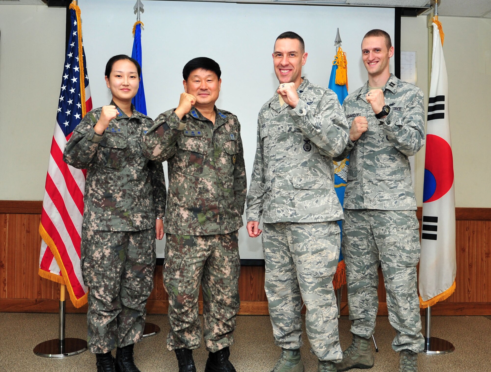 Republic of Korea air force Capt. Yoo Jin Kyoung, Military Police Squadron operations officer, ROKAF Lt. Col. Gyu Hwan Lee, MPS commander, Lt. Col. Jason Beck, 51st Security Forces Squadron commander, and Capt. Joseph Schneider, 51st SFS operations officer, celebrate the signing of the Air Force and ROKAF Agreement for Base Security and Law Enforcement on Osan Air Base, ROK, Sept. 24, 2013. Safeguarding equipment and protecting and serving base personnel and their families are top priorities for both squadrons. (U.S. Air Force photo/Airman 1st Class Ashley J. Thum)