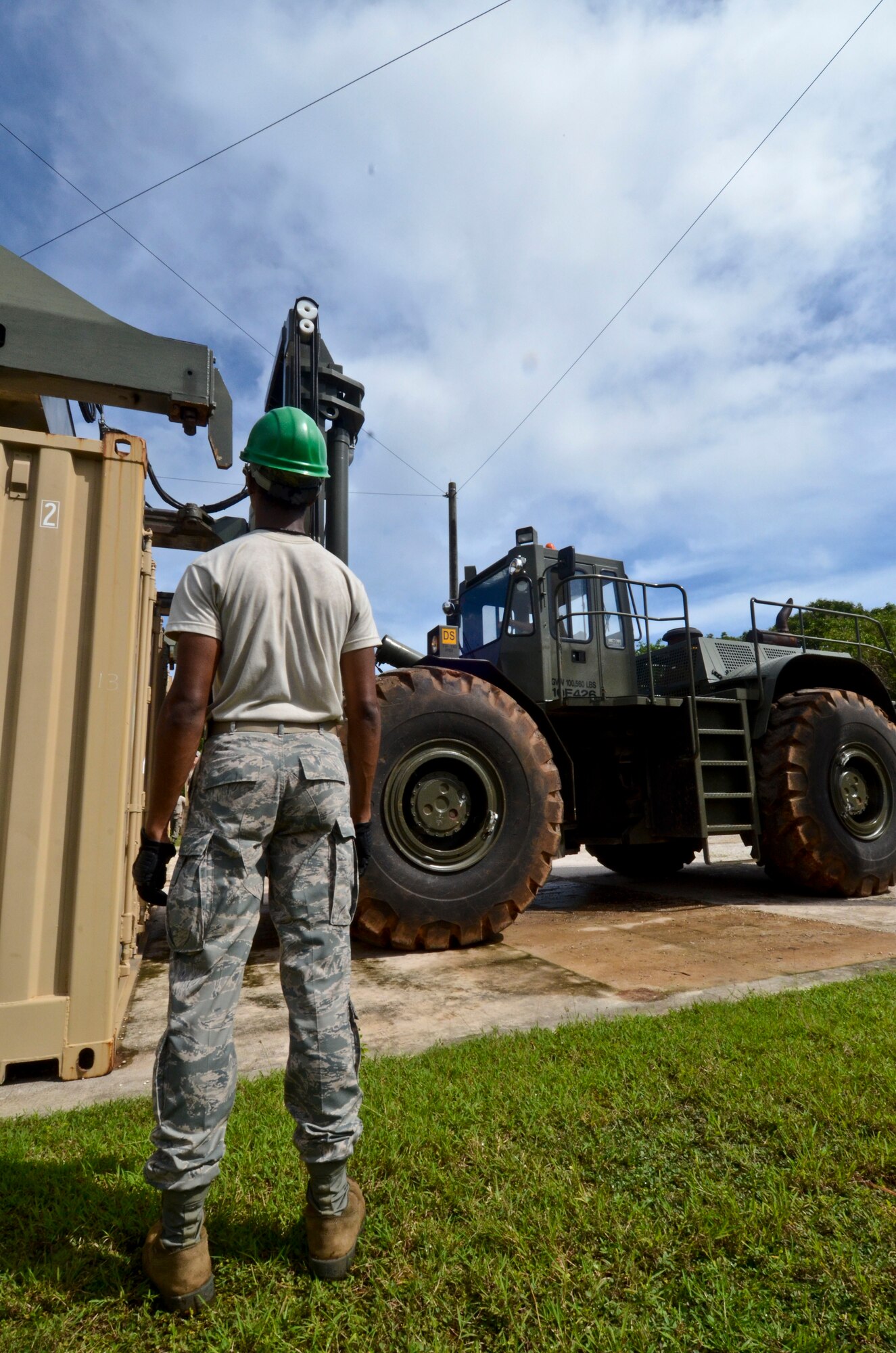 Airman 1st Class Shakim Adkins, 36th Munitions Squadron munitions storage crew member, stands by while another Airman lowers a storage container, Sept. 24, 2013, on Andersen Air Force Base, Guam. The 36th MUNS is responsible for a storage area spanning more than 5,500 acres and encompassing 143 storage facilities, seven operating locations, 23 sited storage revetments, and 160 non-sited revetments.
(U.S. Air Force photo by Senior Airman Cierra Presentado/Released)
