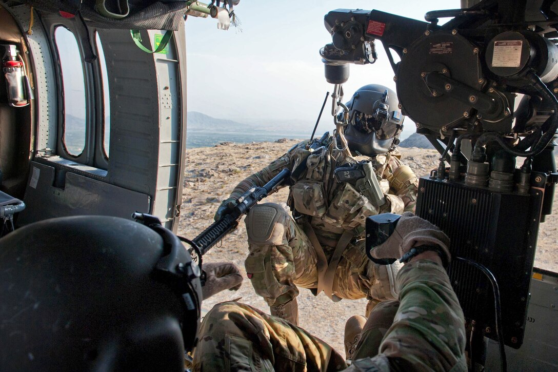 A UH60 Black Hawk helicopter hoists U.S. Army Sgt. Brandon Coburn back