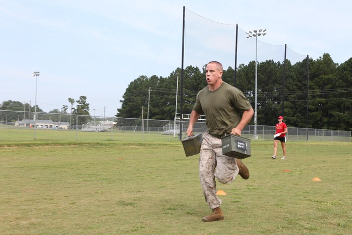 Marines competed in the High Intensity Tactical Training Ultimate Warrior Challenge at the HITT center aboard Marine Corps Air Station New River, Sept. 13. A Marine sprints with ammo cans in hand as part of the modified maneuver under fire portion of the challenge.