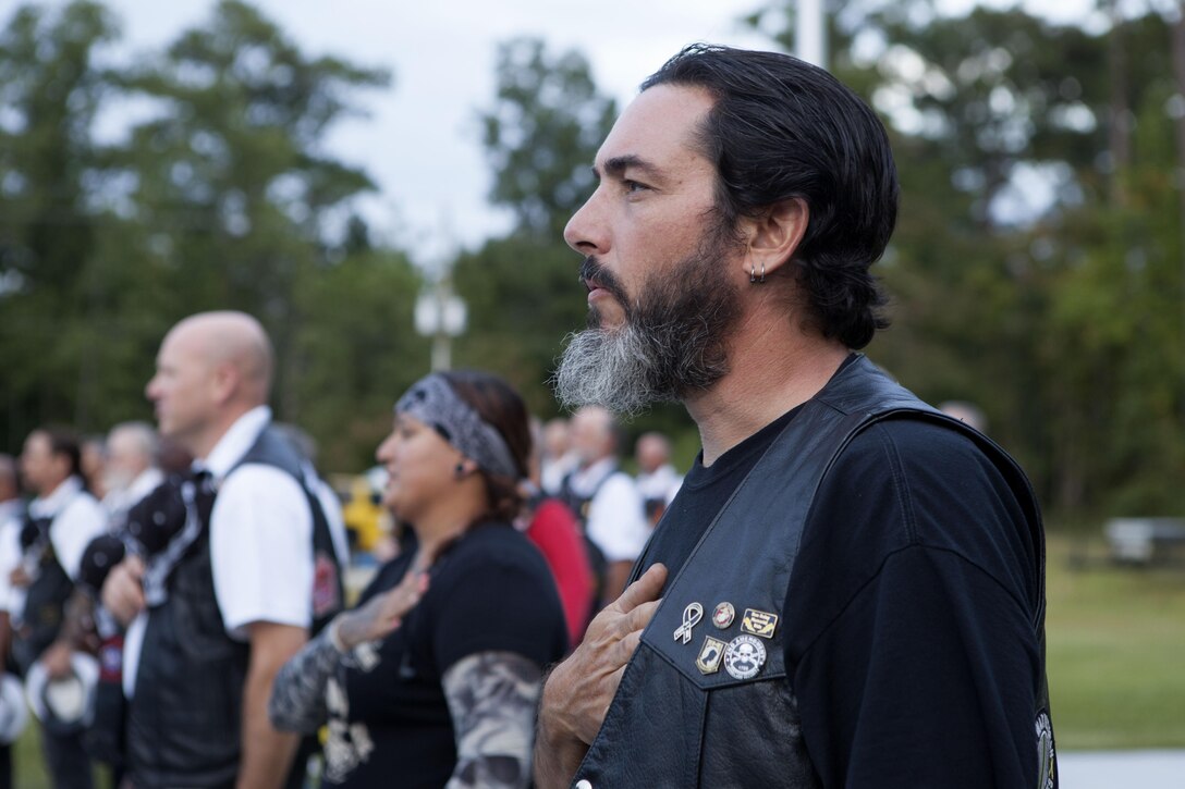 Chris Lauret, a Marine Corps veteran, holds his hand to his heart during the national anthem during the National Prisoners of War and Missing in Action Recognition Day ceremony at Lejeune Memorial Gardens in Jacksonville, N.C., Sept. 20