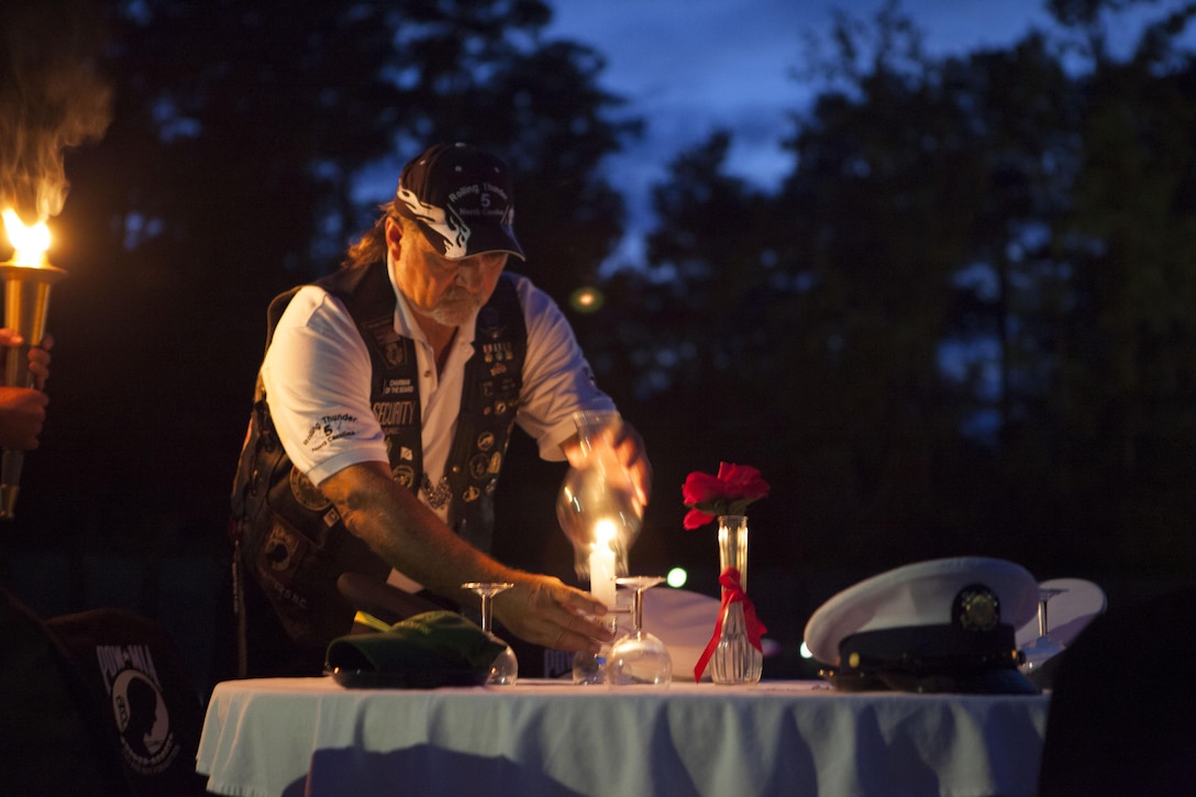 A member of Rolling Thunder Chapter NC-5 lights a candle on the missing man table during the National Prisoners of War and Missing in Action Recognition Day ceremony at Lejeune Memorial Gardens in Jacksonville, N.C., Sept. 20.


