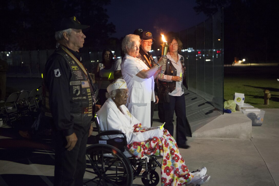 Participants of the National Prisoners of War and Missing in Action Recognition Day ceremony carry a torch during the Walk of the Wall procession with a ceremonial Flame of Freedom at Lejeune Memorial Gardens in Jacksonville, N.C., Sept. 20.


