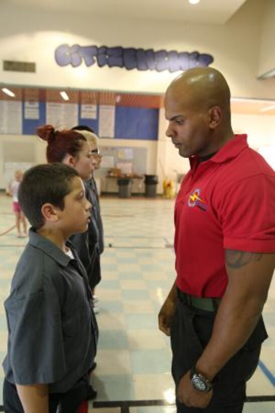 Lance Corporal Luis Castro, adjutant clerk with Headquarters Battalion on Marine Corps Logistics Base Barstow, questions a SHOCK student about his homework during the SHOCK class in Apple Valley, Sept. 15.


