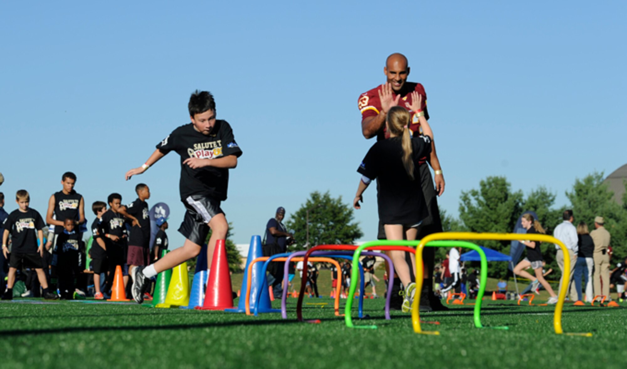 Washington Redskins linebacker Bryan Kehl high-fives a young girl during the Salute to Play 60 Military Challenge Sept. 24, 2013, at Joint Base Andrews, Md. The initiative is part of the National Football League’s larger Play 60 campaign, which is designed to encourage kids to be active for 60 minutes a day to help reverse the trend of childhood obesity.
