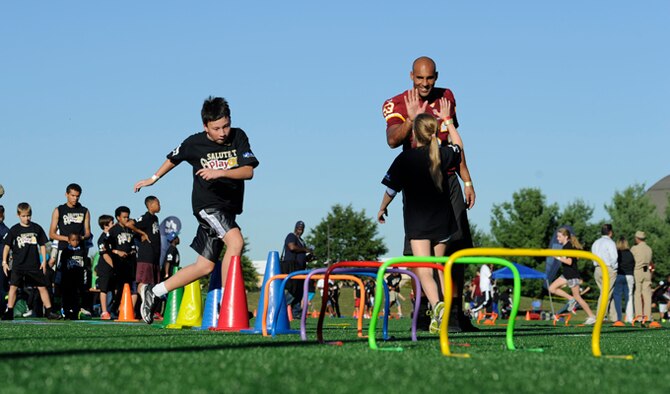 Washington Redskins linebacker Bryan Kehl high-fives a young girl during the Salute to Play 60 Military Challenge Sept. 24, 2013, at Joint Base Andrews, Md. The initiative is part of the National Football League’s larger Play 60 campaign, which is designed to encourage kids to be active for 60 minutes a day to help reverse the trend of childhood obesity.