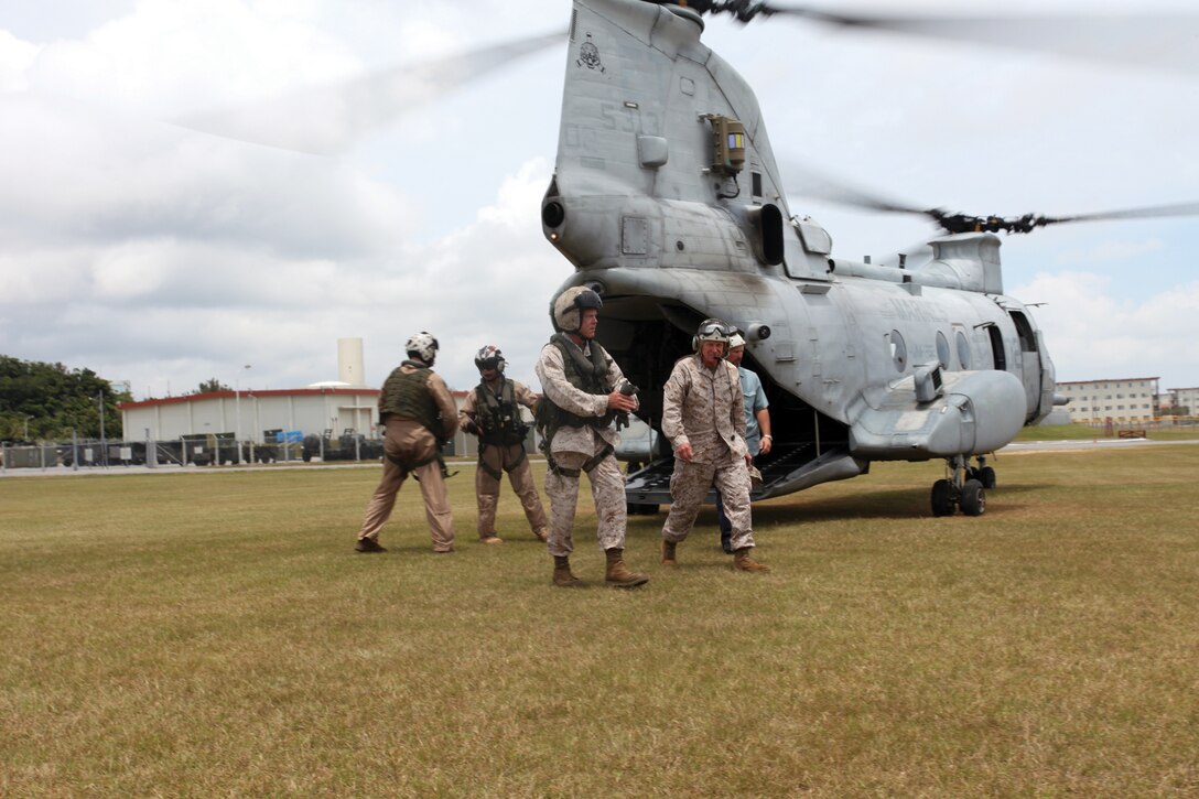Gen. James F. Amos, center, exits the back of a CH-46E Sea Knight helicopter July 18 at Camp Hansen, where Amos spent time speaking with service members. Amos is the commandant of the Marine Corps and a member of the Joint Chiefs of Staff. 